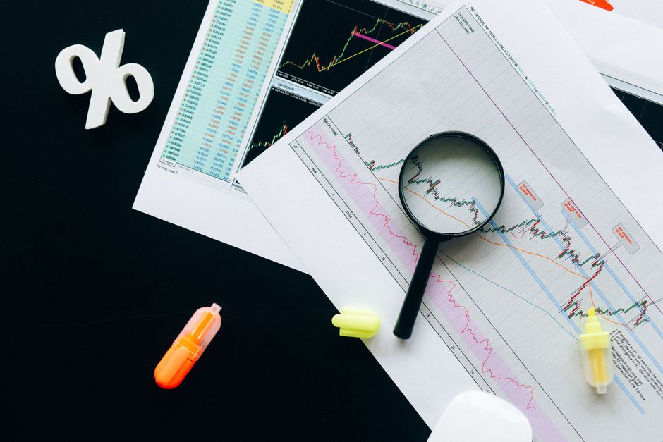 A comparative profit and loss statement displayed on a tablet screen next to a calculator.