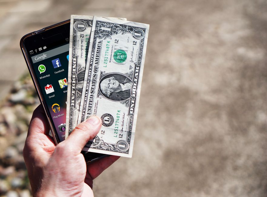 A person taking a photo of a check for mobile deposit on a smartphone.