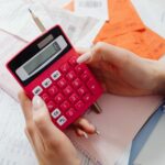 A desk with financial spreadsheets, a pen, and a calculator representing accounting and finance functions