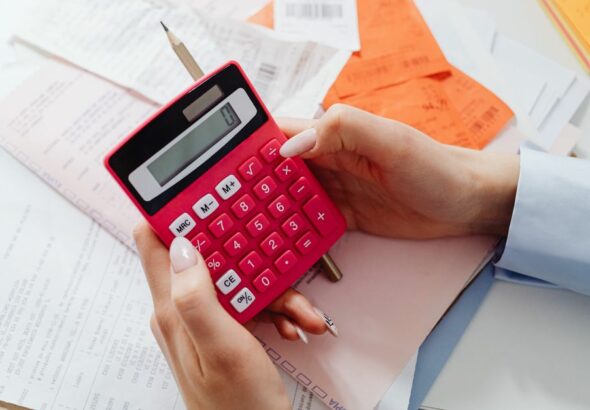 A desk with financial spreadsheets, a pen, and a calculator representing accounting and finance functions