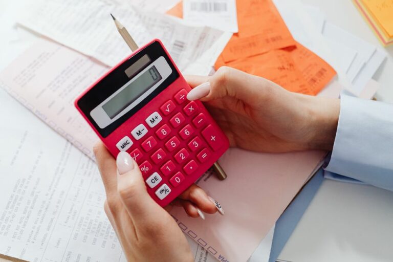 A desk with financial spreadsheets, a pen, and a calculator representing accounting and finance functions