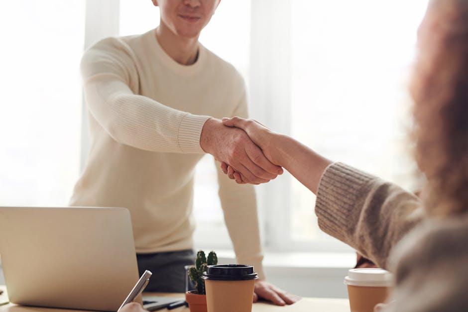 Two business partners shaking hands in a professional modern office