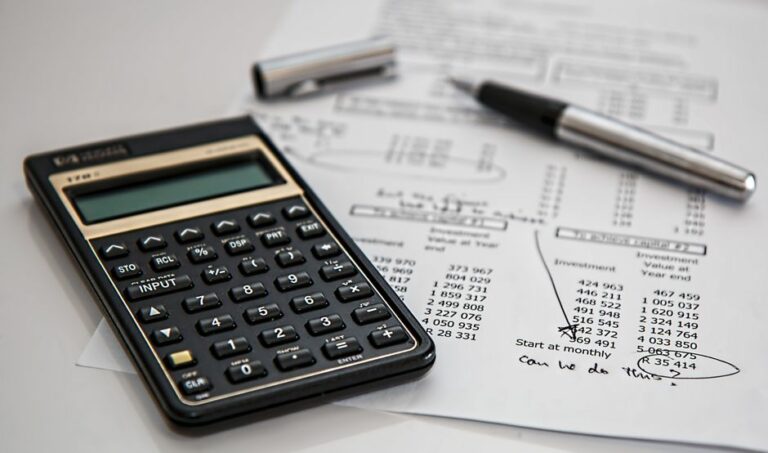 A close-up of a calculator on top of financial statements and balance sheets