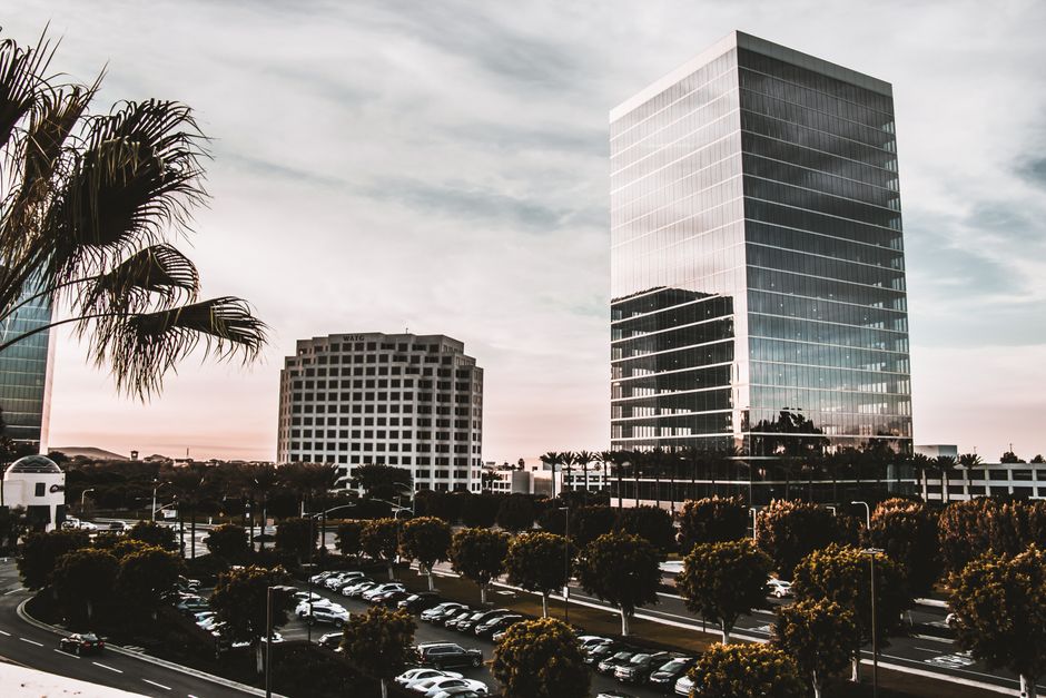 A successful finance executive looking at a city skyline from a modern office