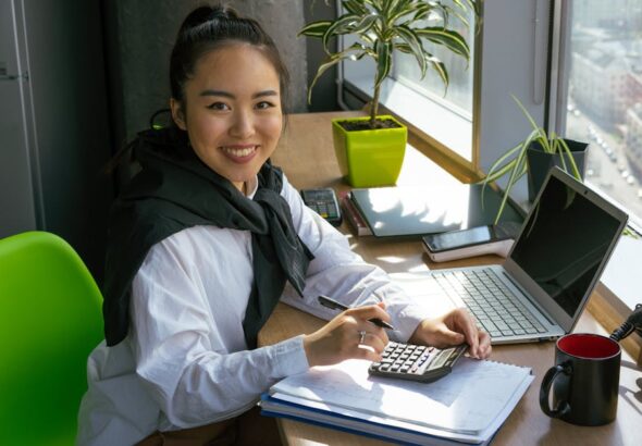 A self-taught student studying accounting concepts on a laptop at a bright desk
