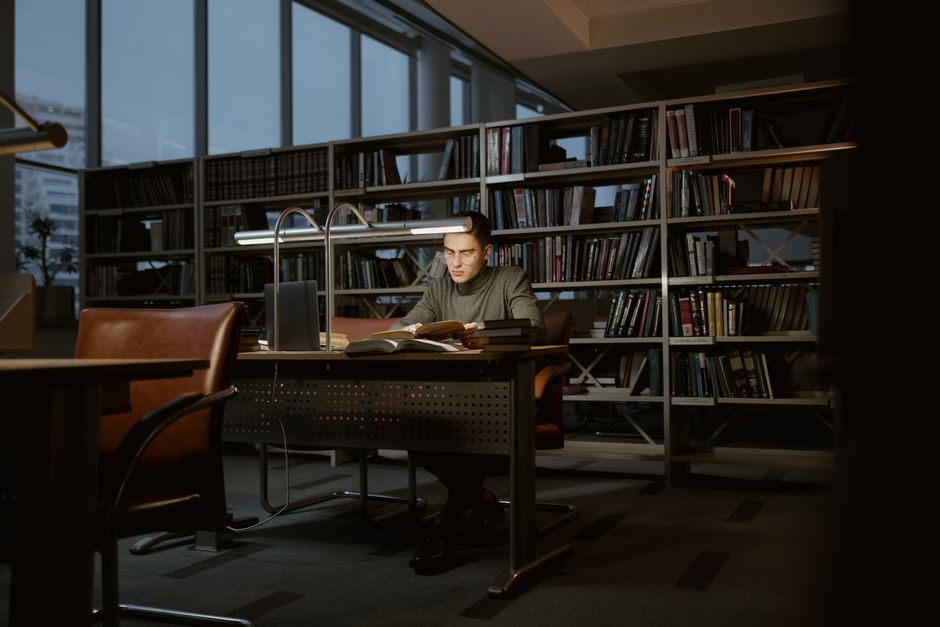 A modern university library with researchers studying accounting texts and databases.