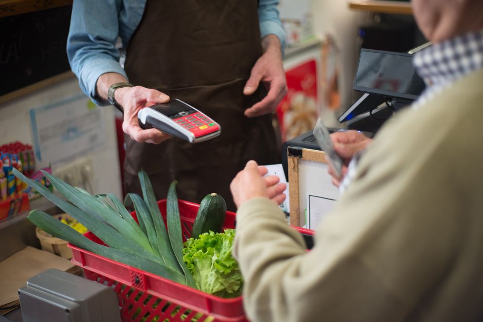 A customer paying at a retail store checkout, representing state sales tax.