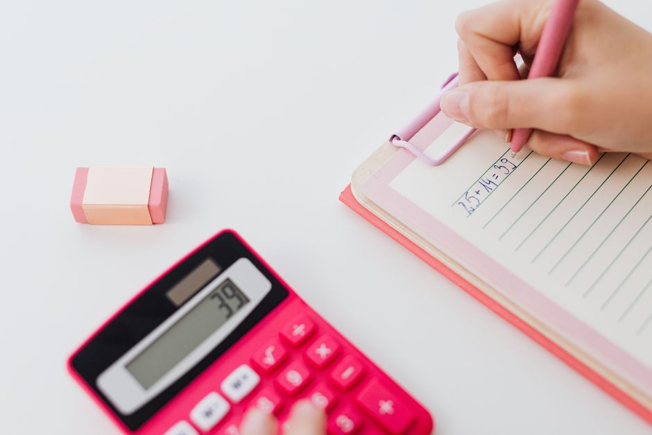 A calculator and notebook on a desk for bookkeeping calculations
