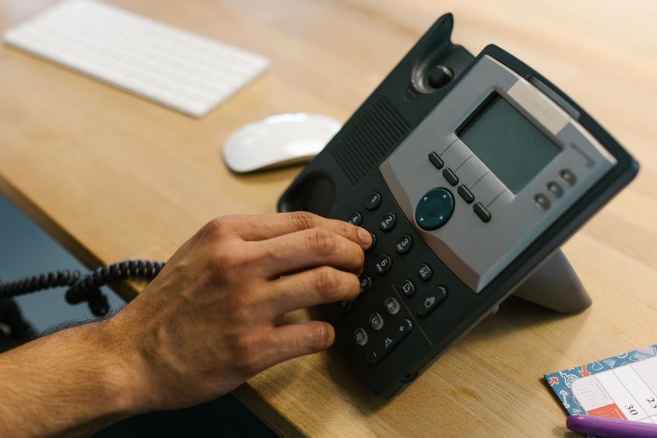 A business professional ready to receive an inquiry call at a desk.