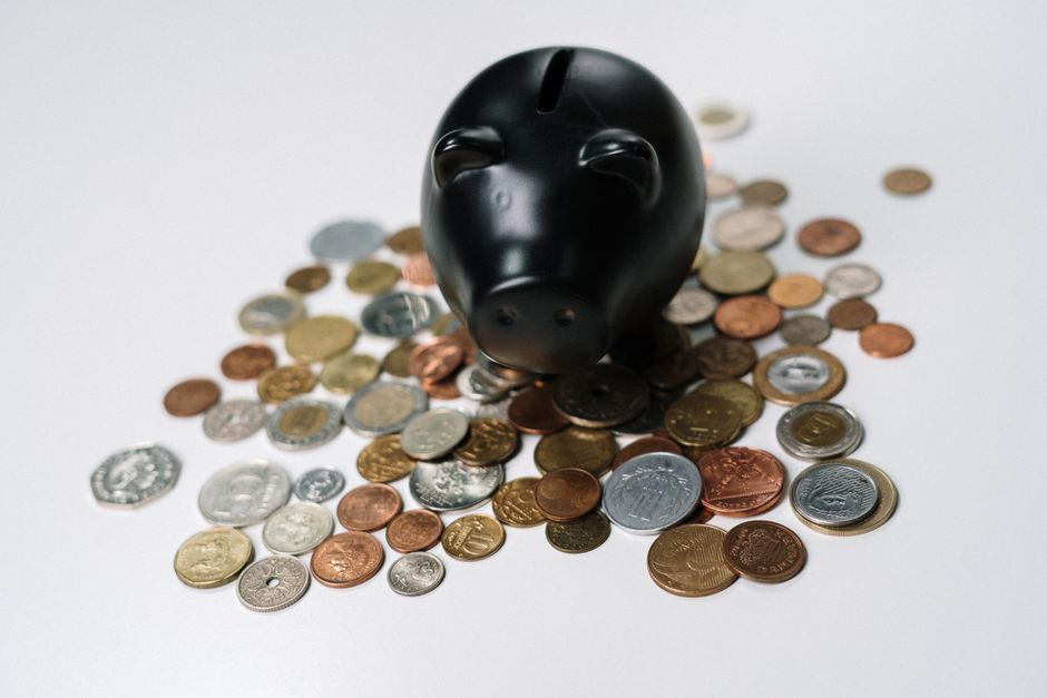 An investor putting coins into a savings jar representing dollar cost averaging.