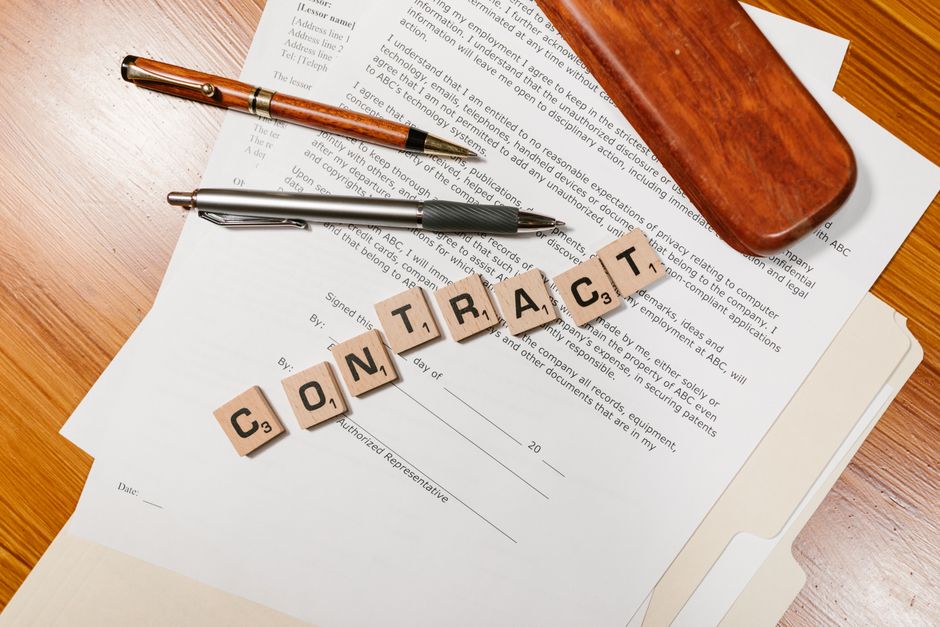 Digitized legal contracts being processed by data analytics software on an office computer.