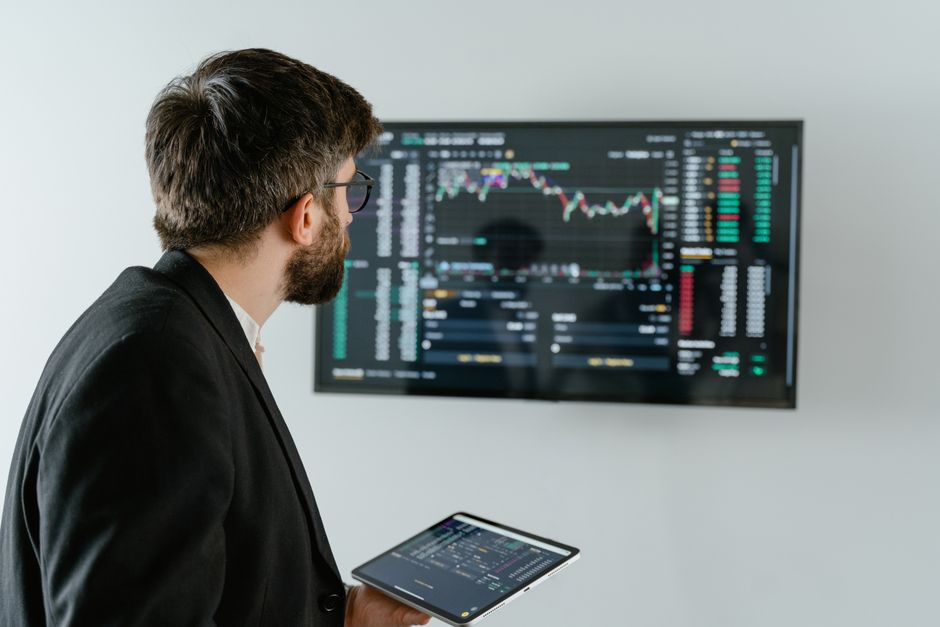 An office desk with multiple monitors displaying stock market data charts