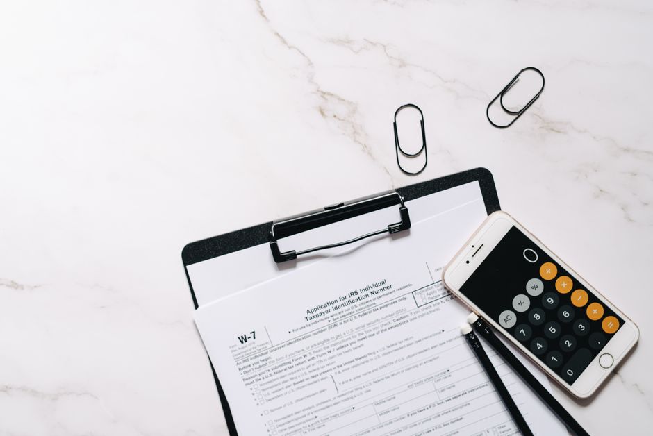 A clipboard with financial documents and a calculator comparing different tax deduction tiers.