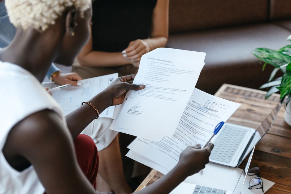 Someone comparing financial documents and transactions on a desk.