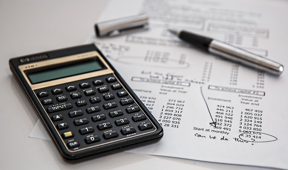 A balance sheet comparison document with a calculator.