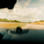 A car driving on a scenic highway representing business travel and standard mileage.