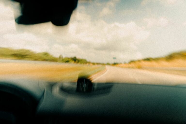 A car driving on a scenic highway representing business travel and standard mileage.