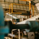 A large robotic assembly arm working in an advanced manufacturing facility.