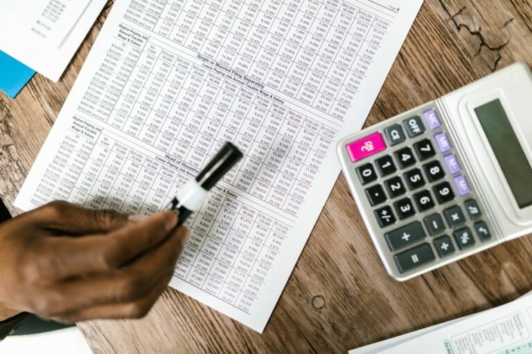 An accountant reviewing a balance sheet and reconciliation spreadsheet.