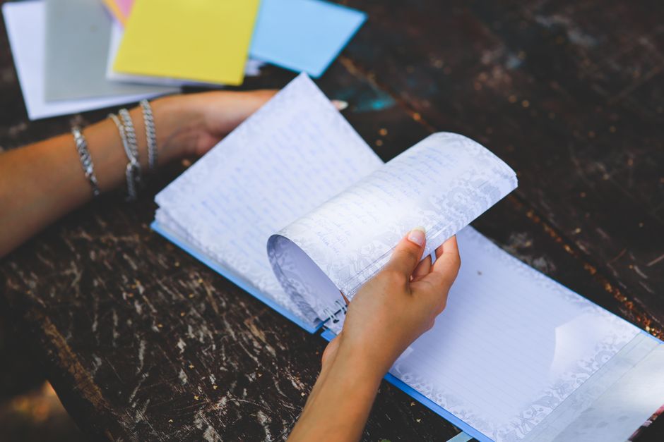 An accountant writing a journal entry adjustment in a ledger.