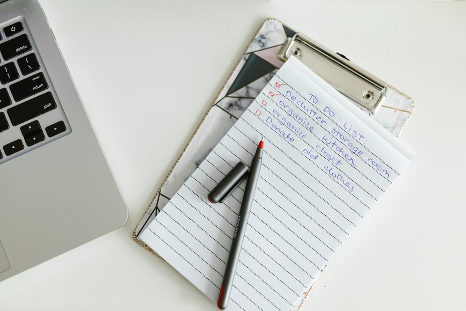 A detailed procedure checklist next to a pen on an office desk.