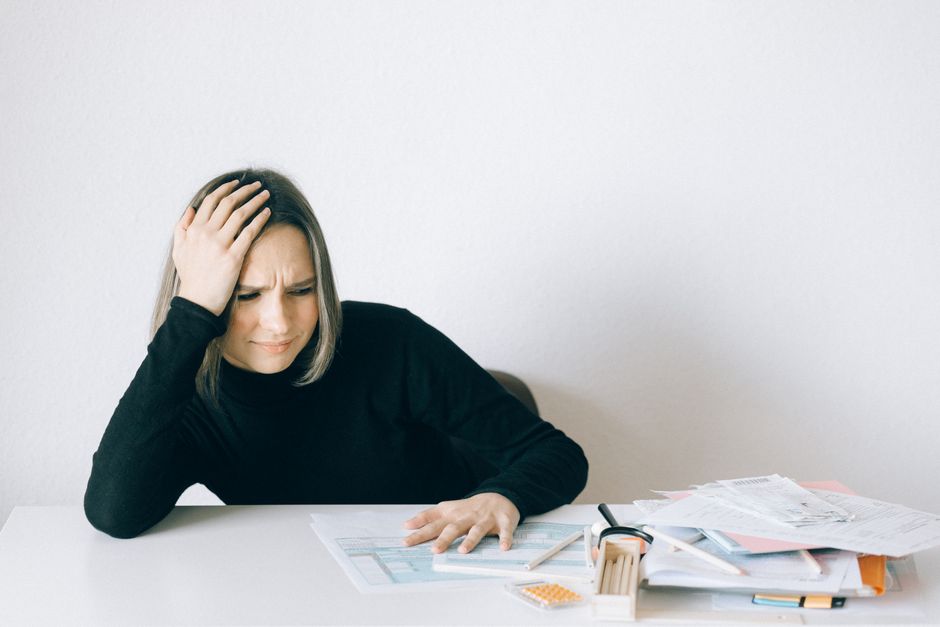 A business owner calculating finances indicating economic challenges.