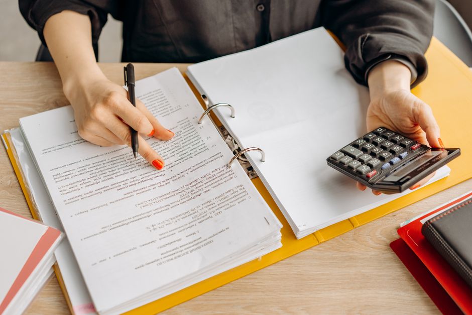 A financial procedure manual open on a wooden office desk.