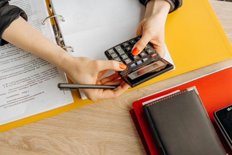Small business owner reviewing monthly bookkeeping costs with a calculator
